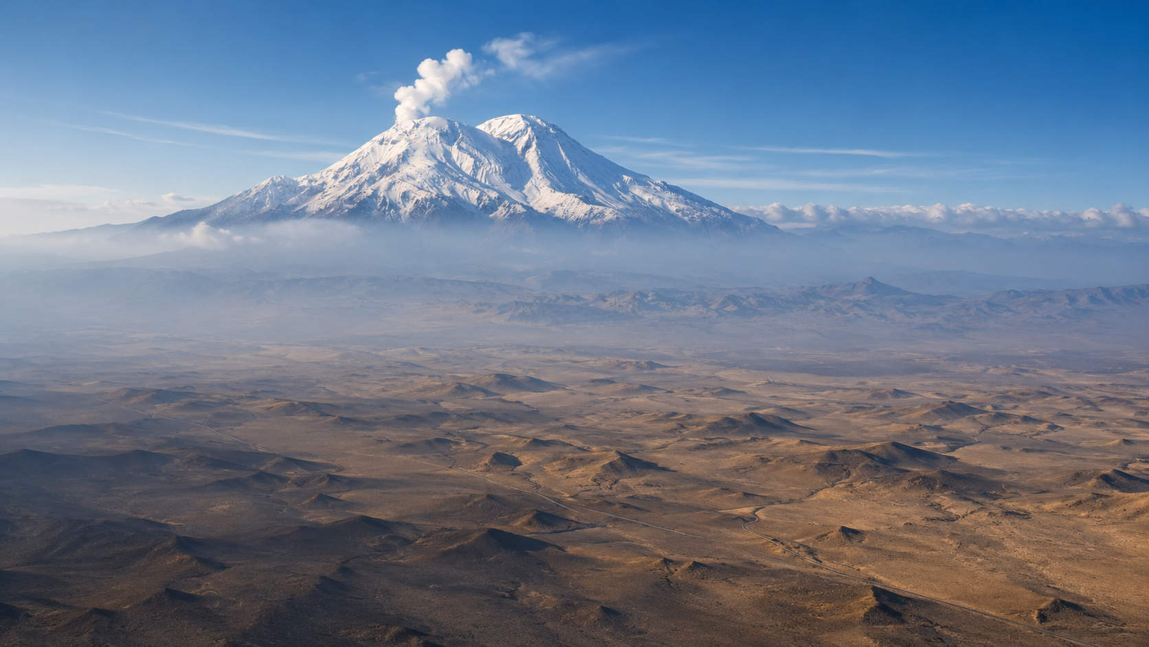 Vista aérea del volcán Taftán, cubierto de nieve, con una fumarola en su cüspide, Irán